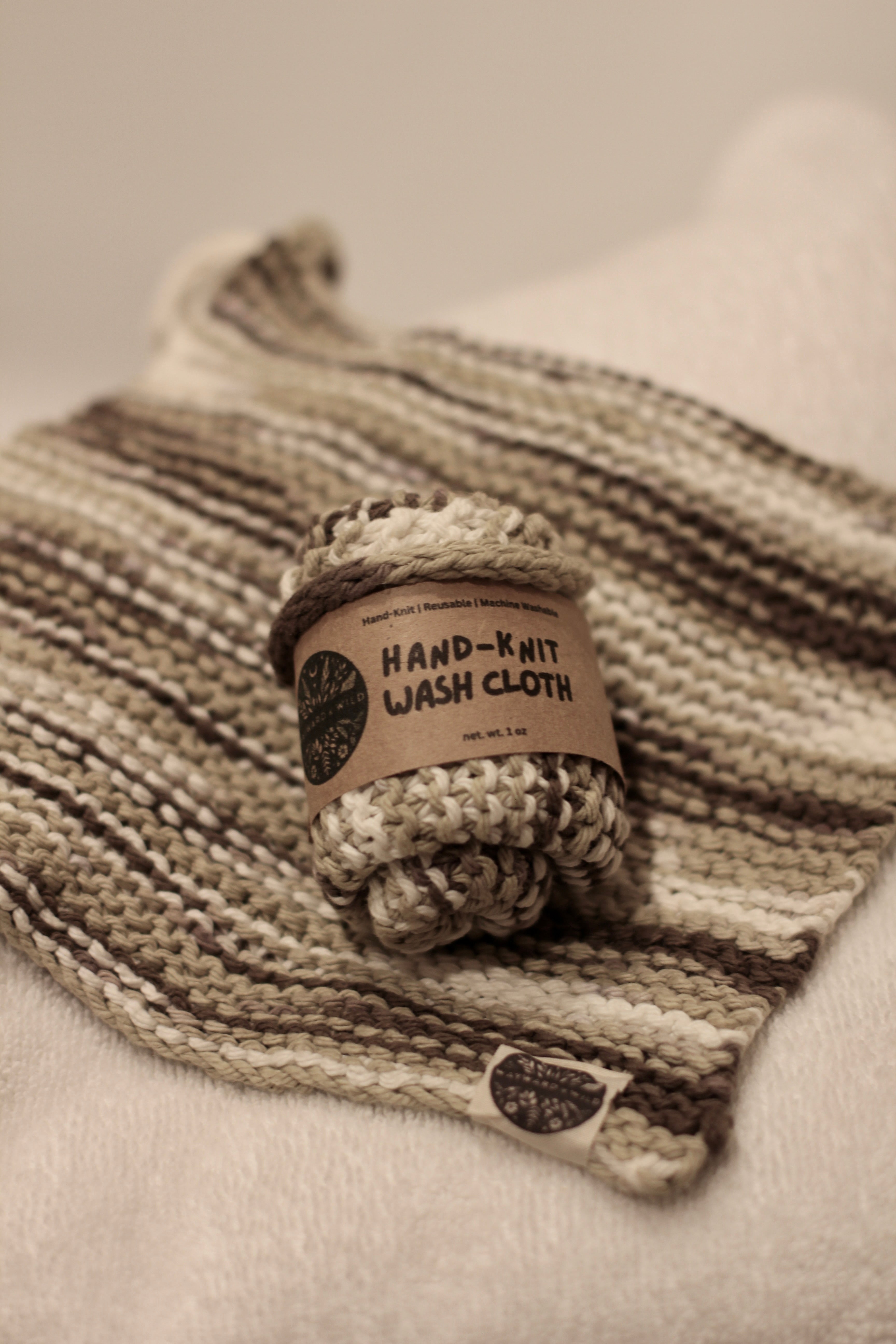 Hand-knit wash cloth with a label on a textured surface